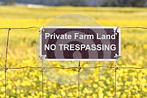 Private Farm Land No Trespassing sign posted on a barbed wire fence