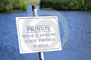 Private fishing and swimming strictly prohibited sign at blue lake