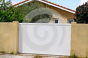 Private gate in white pvc plastic in street view of suburbs house