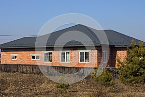 Private house of red bricks under a gray tiled roof