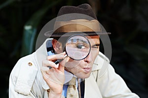 Private investigator, eye in magnifying glass and portrait of man for detective, searching and looking. Spy