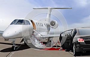 Private jet and black car waiting on landing strip in airport