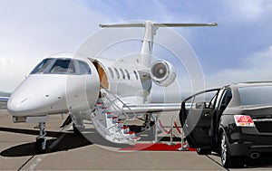 Private jet and black car waiting on landing strip in airport photo