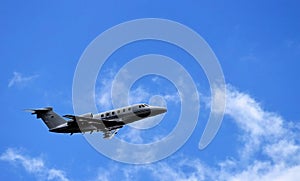 Private jet flying with blue sky and clouds
