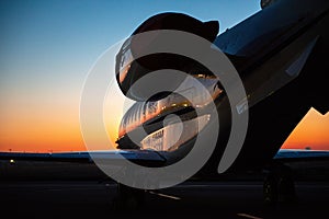 Private jet plane parking at the airport. Private airplane at sunrise. Early morning at airport apron.