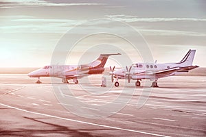 Private jet planes parking at the airport. Private airplanes at sunset,
