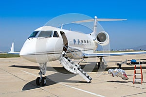 A private jet sits ready at the airfield.