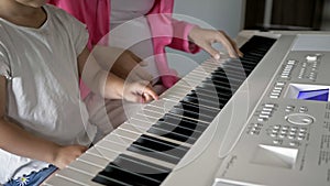 Private music teacher giving piano lessons to little girl. Hands close up.