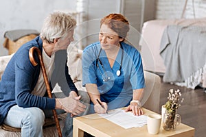 Private nurse and elderly man discussing the contract