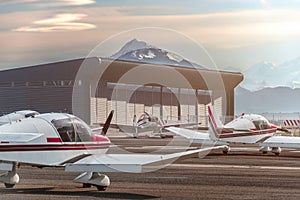 Private propeller planes parked at the airport. Private airplanes at sunset.