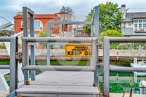 Private Property Keep Out sign against wooden dock on canal in Long Beach CA