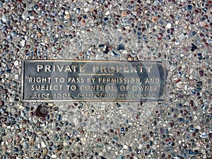 Private property metal plate on sidewalk