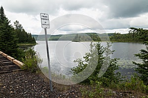 Private Property No Trespassing Sign on Old Train Tracks Rail Path Forest Clouds