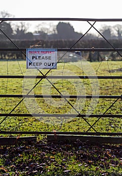 Private property please keep out printed sign on metal fence