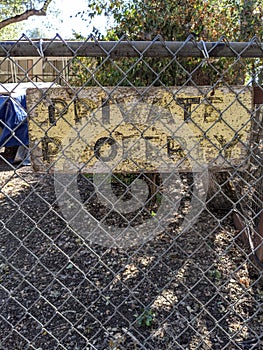 Private property yellow sign on  chain link fence