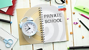 Private school text on notepad with alarm clock,