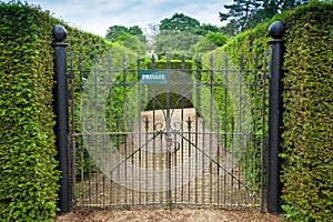 Private sign attached to an ornate wrought iron gate photo