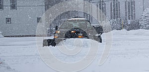 Private snow plow clearing parking lot for businesses