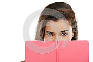 Private time between the pages of a book. Studio portrait of a young woman reading a book against a white background.