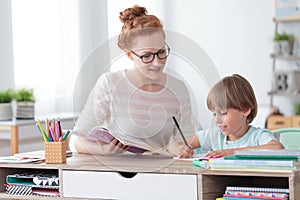 Private tutor helping young student photo