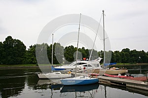 Private yachts, motorboats and boats moored at the old wooden pier.