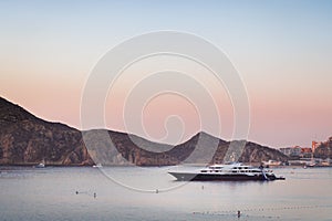 Private yatch in the harbor of Cabo San Lucas with paddleboarders. photo
