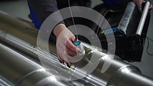 Pro conducts nondestructive testing, NDT, on a cylindrical metal component. Ultrasonic flaw detection procedure applied
