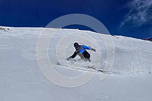Profesionálny lyžiar robí zákruty na prachovom snehu dole svahom na pozadí hôr v Nízkych Tatrách na Slovensku. Pojem