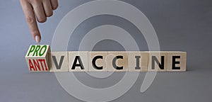 Pro-vaccine vs Anti-vaccine symbol. Doctor hand points at cubes with words Anti-vaccine vs Pro-vaccine. Beautiful grey background