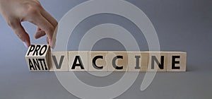 Pro-vaccine vs Anti-vaccine symbol. Doctor hand turns a cube and changes the words Anti-vaccine to Pro-vaccine. Beautiful grey