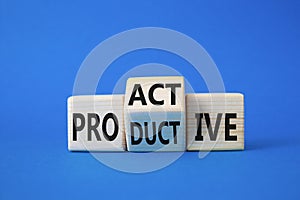 Proactive and Productive symbol. Wooden cubes with words Productive and Proactive. Beautiful blue background. Business concept.