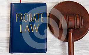 PROBATE LAW - words on a dark blue book on a light wooden background with a judge\'s hammer on the stand