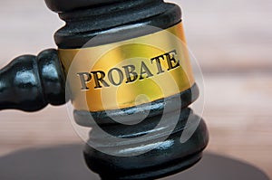 Probate text engraved on gavel with blurred wooden cover background. Legal and law concept