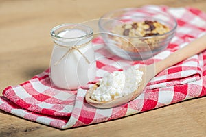 probiotic milk kefir grains, Tibetan mushrooms on wooden spoon, kefir milk in glass containers and cereals on background. health