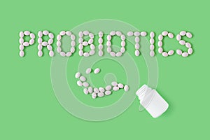 Probiotics word made of pills on green background. Flat lay, top view, free copy space. photo