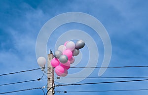 Problem of garbage pollution of the environment with waste, the ecology of the earth. Colored balloons stuck on pole after a