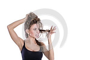 Problem with hair. Young woman worriedly looks at the tangled hair.