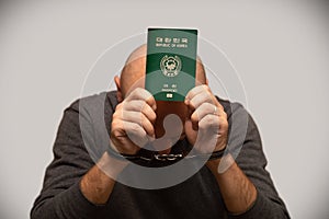 The problem of illegal immigration of refugees from South Korea, an immigrant from Korea in handcuffs. Illegal border crossing, de