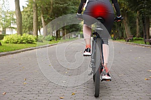 Problem of injured coccyx. Woman riding bicycle on road