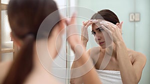 Problem Skin. Woman Crushing Spot On Face And Looking In Mirror