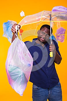 Problem of trash, plastic recycling, pollution and environmental concept - funny african american man carrying garbage