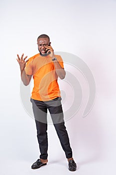 Problematic young Nigerian man making phone call isolated on a white background