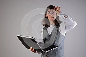 Problems with equipment, computer failure. Service for a laptop. A young man holds a laptop in his hands,