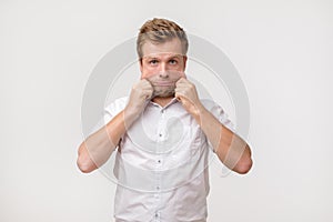 Problems with skin and wrinkles. Handsome caucasian man in white shirt stretching his skin on face.