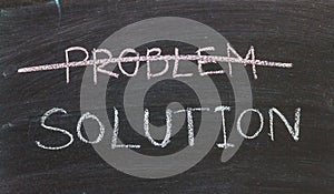 Problems Solutions handwritten with white chalk on a blackboard