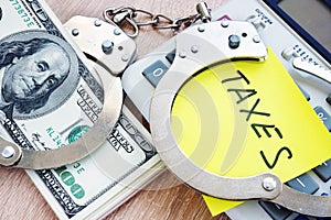 Problems with taxes. Handcuffs and money. Tax evasion concept.