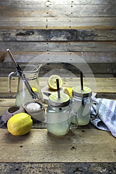Proccess of making detox water with lemon in a glass jar with a handle, lid, and straw photo