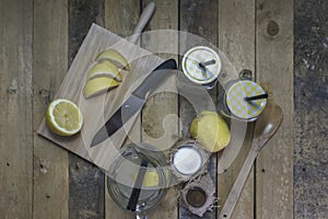 Proccess of making detox water with lemon in a glass jar with a handle, lid, and straw photo