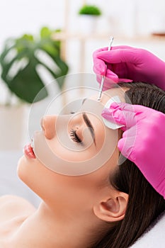 A procedure for cleansing the skin of the face from blackheads and acne. Cosmetologist treats problematic skin