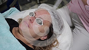 The procedure of laser correction of the face in a cosmetic clinic.